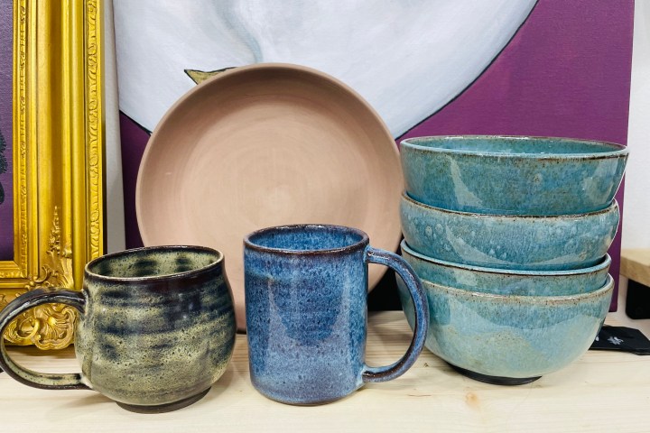 Assorted ceramic dishes and mugs displayed on a shelf.
